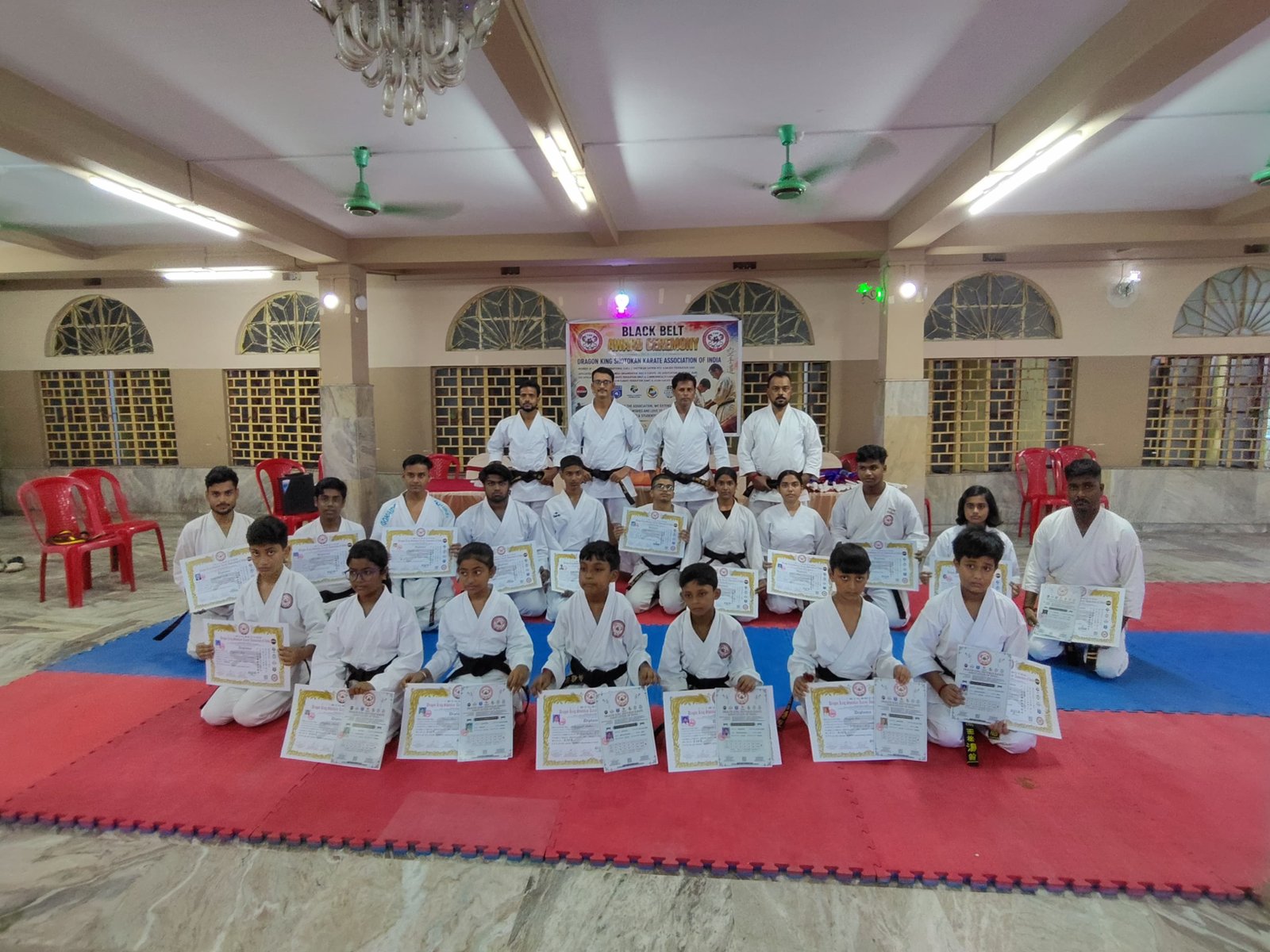 Final group photo of recipients holding their certificates at the Black Belt Award Ceremony