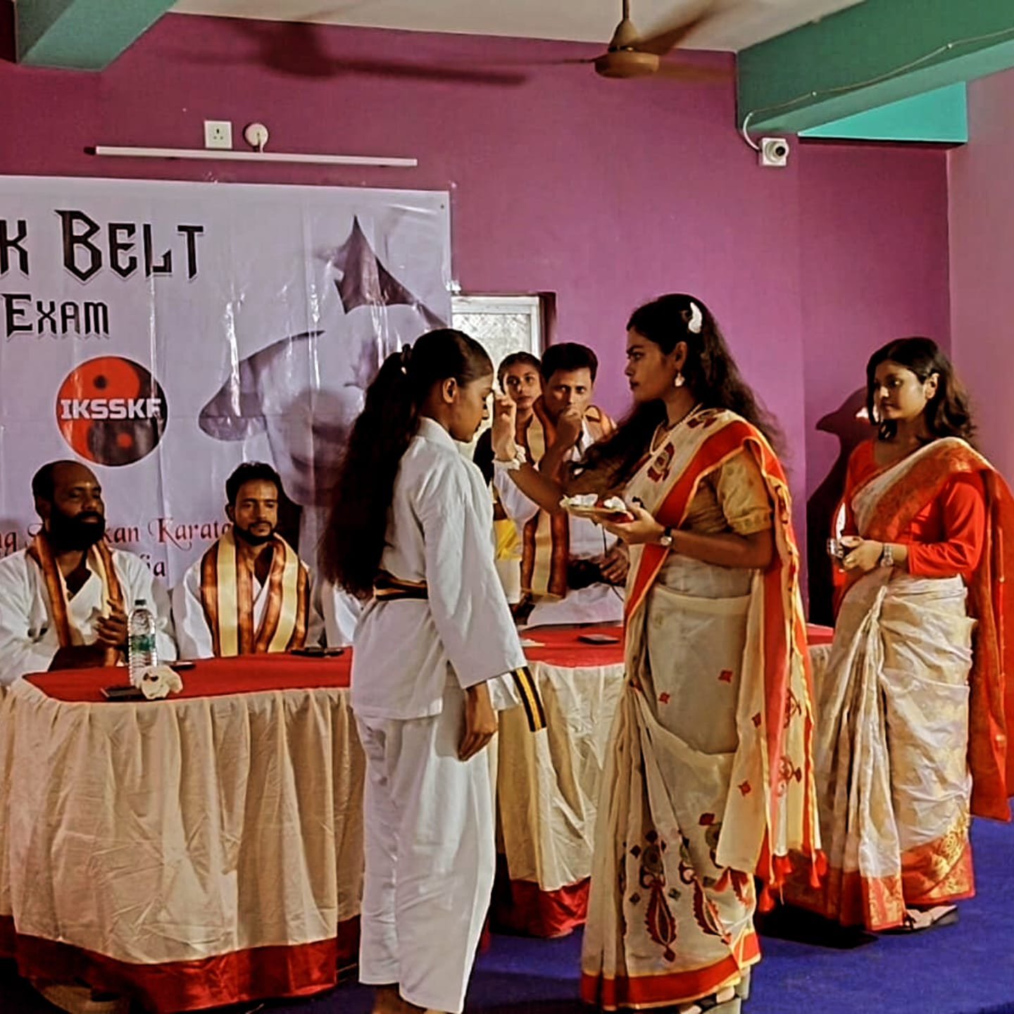 Senior black belts bowing to one another in two facing rows before the exam