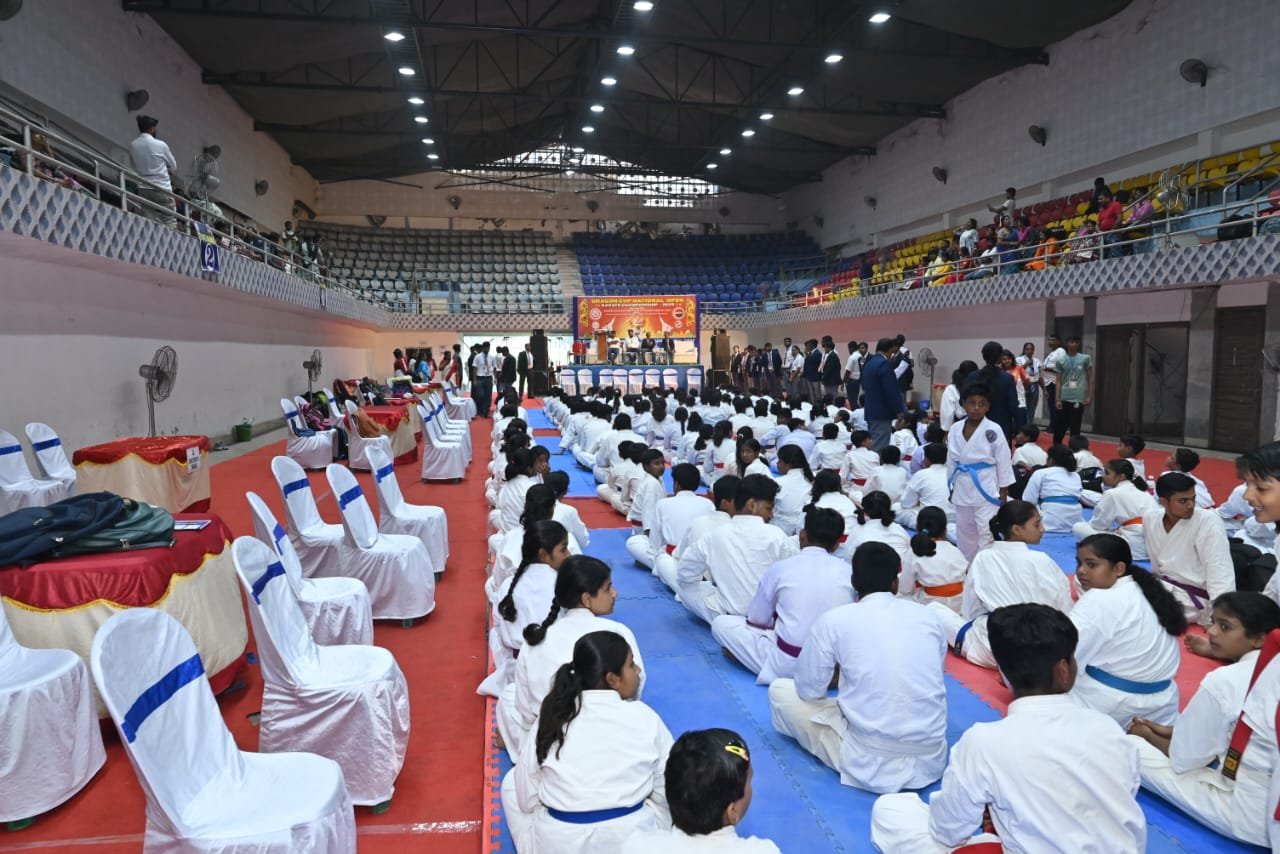 Competitors seated on the mat with the Dragon Cup National Open stage in the background